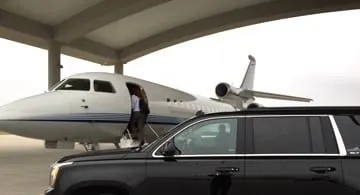 Luxury SUV waiting at a private jet FBO for an Austin airport pickup