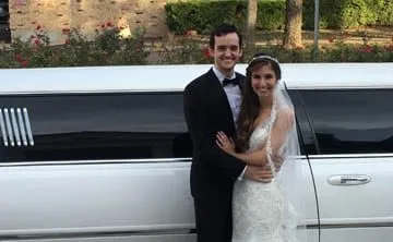 Bride and groom beside a white stretch limousine in Austin